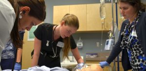 UBC medical student Robyn Buna, nursing student Bobbi Bennett and medical student Alison Leighton work to solve a patient emergency while Karen Whaley, Pritchard Simulation Centre clinical educator watches the situation unfold.